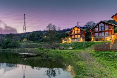 a large house next to a body of water at Luxury Lodge 18 by Ashgrove Leisure in Moffat