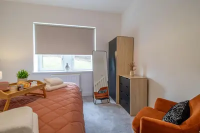 a living room with a bed and a table and a window at William Wallace View - 5 Bedrooms in Stirling in Stirling