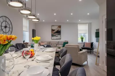 a dining room with a table with flowers and chairs at William Wallace View - 5 Bedrooms in Stirling in Stirling