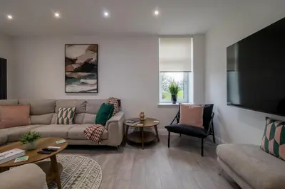 a living room with a couch and a flat screen tv at William Wallace View - 5 Bedrooms in Stirling in Stirling