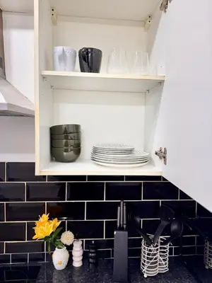 a kitchen with a sink and a shelf with dishes at Stay With OG - Modern Two-Bedroom Apartment in Moffat