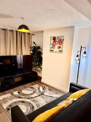 a living room with a couch and a tv at Stay With OG - Modern Two-Bedroom Apartment in Moffat