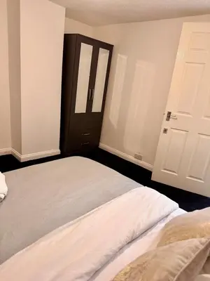 a bedroom with a bed and a black door at Stay With OG - Modern Two-Bedroom Apartment in Moffat