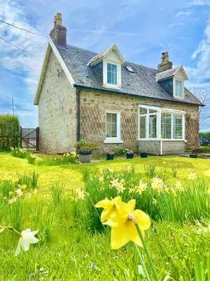 a stone house with flowers in front of it at Craig Na Barnach in Furnace