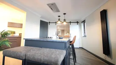 a kitchen with a counter and a bar in a room at Stylish 2 Bed Duplex with Balcony & Parking Merchant City in Glasgow