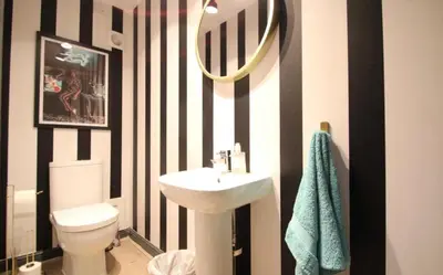 a black and white bathroom with a sink and a toilet at Stylish 2 Bed Duplex with Balcony & Parking Merchant City in Glasgow