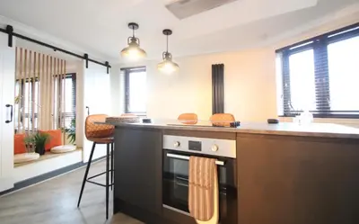 a kitchen with a stove and a counter top at Stylish 2 Bed Duplex with Balcony & Parking Merchant City in Glasgow