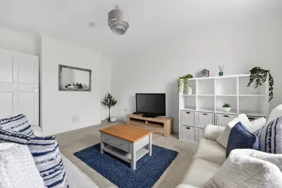 a white living room with a couch and a table at Troon Golf by the Sea in Troon