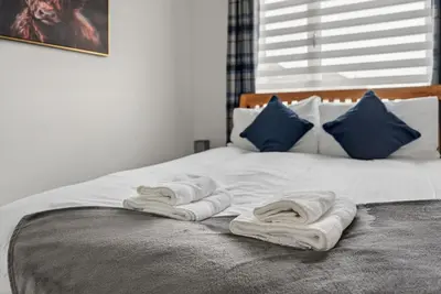 a bed with two towels on top of it at Troon Golf by the Sea in Troon