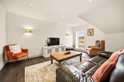 a living room with a couch and a tv at Stunning Sea Views - 3BD & Free Parking in Oban