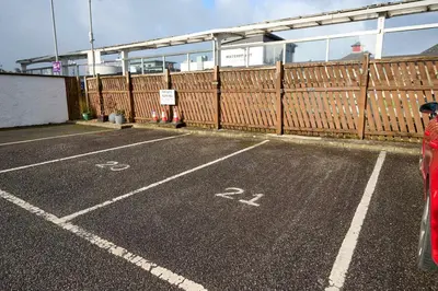 an empty parking lot next to a fence at Stunning Sea Views - 3BD & Free Parking in Oban
