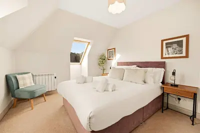 a bedroom with a bed and a desk and a chair at Stunning Sea Views - 3BD & Free Parking in Oban