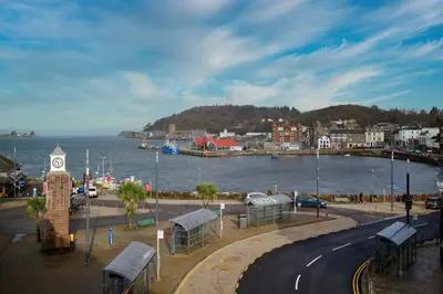 a city with a clock tower next to a body of water at Stunning Sea Views - 3BD & Free Parking in Oban