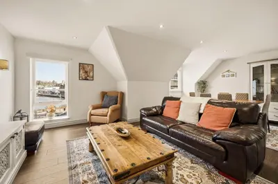 a living room with a leather couch and a table at Stunning Sea Views - 3BD & Free Parking in Oban