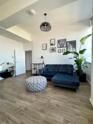 a living room with a blue couch and a table at WHITE LOFT - Modern flat close to the City Centre in Edinburgh