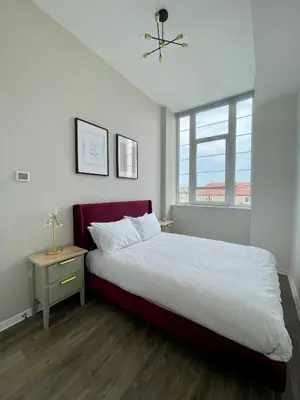 a bedroom with a large bed and a window at WHITE LOFT - Modern flat close to the City Centre in Edinburgh