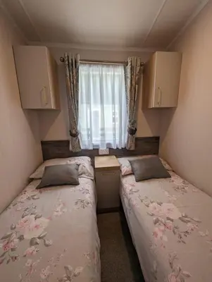 two beds in a small room with a window at Swift Bordeaux Sea View No 2 in Dunoon