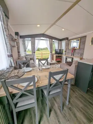 a dining room and living room with a table and chairs at Swift Bordeaux Sea View No 2 in Dunoon