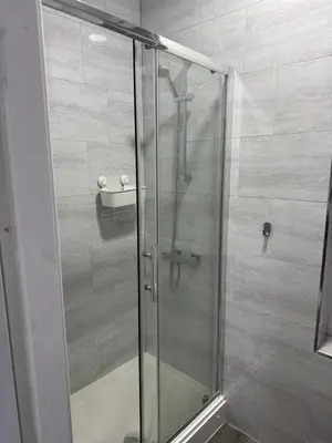 a shower with a glass door in a bathroom at #127 Modern City Suite Digbeth Creative Quarter in Moffat