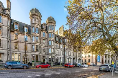 a large building with cars parked in front of it at Old Town Castle View 4 Bedroom 5 beds Sleeps 10 in Edinburgh