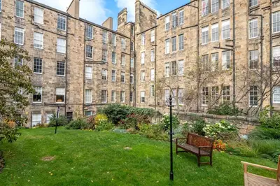 a bench in front of a large brick building at Old Town Castle View 4 Bedroom 5 beds Sleeps 10 in Edinburgh
