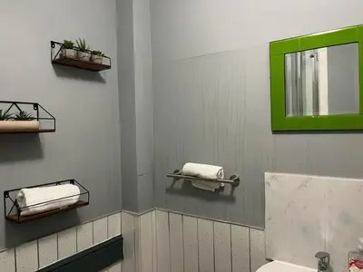 a bathroom with two towels and a green mirror at Lovely Apartment by Meadows 1 in Edinburgh