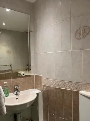 a bathroom with a sink and a mirror at Lovely Apartment by Meadows 1 in Edinburgh