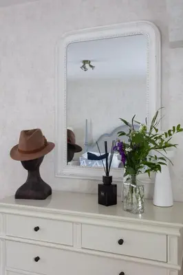 a dresser with a mirror and a hat on it at Stylish Retreat Auchterarder in Auchterarder