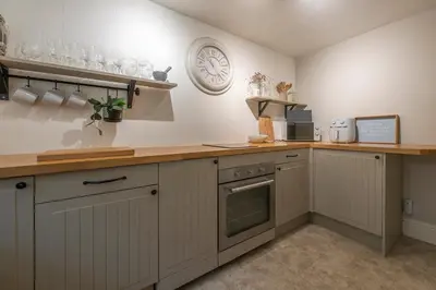 a kitchen with white cabinets and a counter top at Tegfryn in Moffat