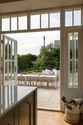 an open door to a patio with a table and chairs at The Hollies Argyll in Tighnabruaich