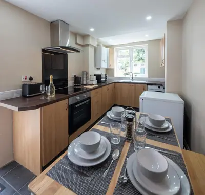 a kitchen with a table with plates on it at 3 Bedroom house In Gloucester in Moffat