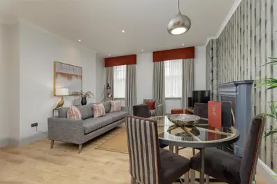 a living room with a table and a couch at Destiny Scotland - Princes Street Residence in Edinburgh
