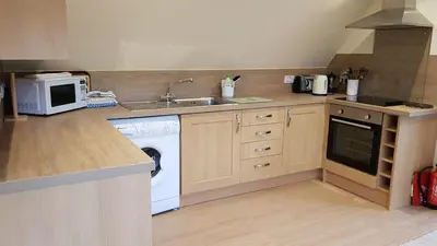 a kitchen with a washing machine and a sink at Blarghour Farm Cottages in Ardchonnell