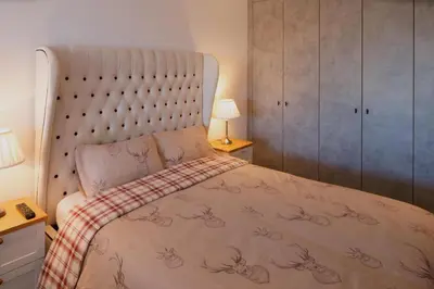 a bedroom with a large bed with a large headboard at CITY CENTRE APARTMENT with Free Secure Underground Parking in Glasgow