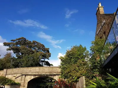 a stone bridge with a building and a tree at The Bridge Inn in Ratho