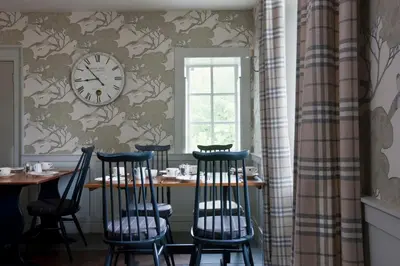 a dining room with a table and chairs and a clock at The Bridge Inn in Ratho