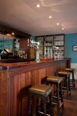 a bar with stools in a room with blue walls at The Bridge Inn in Ratho