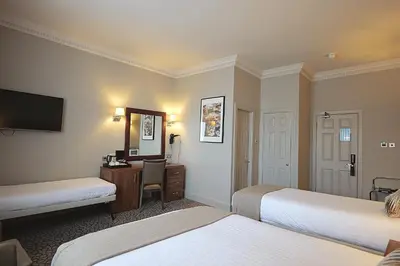 a hotel room with two beds and a mirror at Frederick House Hotel in Edinburgh