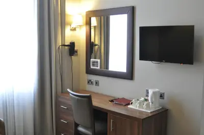 a hotel room with a desk and a television on the wall at Frederick House Hotel in Edinburgh