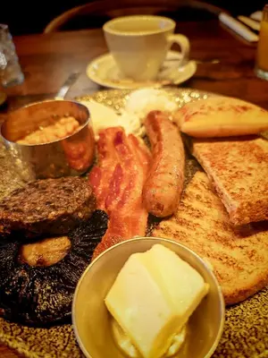 a plate of breakfast food with eggs sausage and bread at Frederick House Hotel in Edinburgh