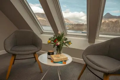 two chairs and a table with a vase of flowers at The Isles of Glencoe Hotel in Glencoe