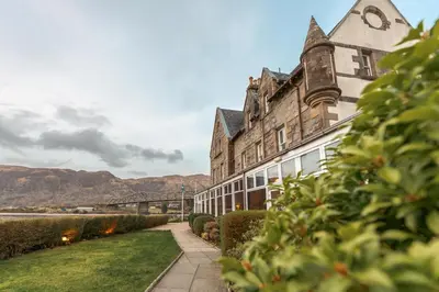 a building with a clock on the side of it at The Ballachulish Hotel in Glencoe