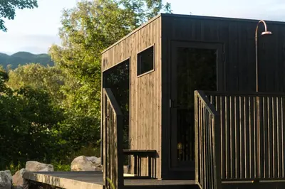 a black tiny house with a black door at RiverBeds - Luxury Wee Lodges with Hot Tubs in Glencoe