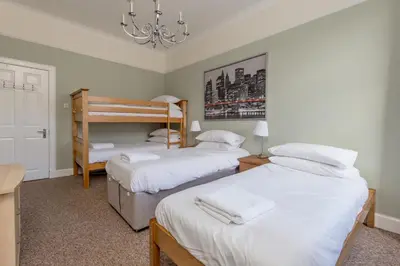 a bedroom with two beds and a chandelier at Rose Street Residence in Edinburgh