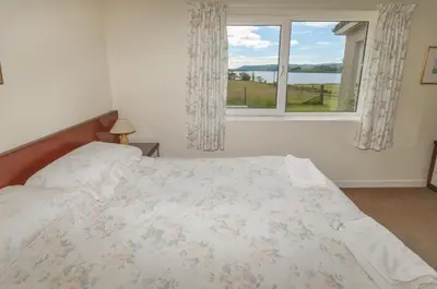 a bedroom with a bed and a window at Blarghour Farm Cottages Overlooking Loch Awe in Ardchonnell