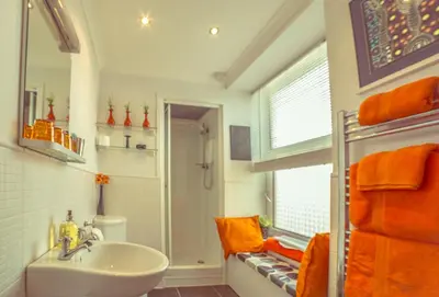 a bathroom with a sink and a shower with orange towels at Dana Villa Holiday Accommodation in Oban