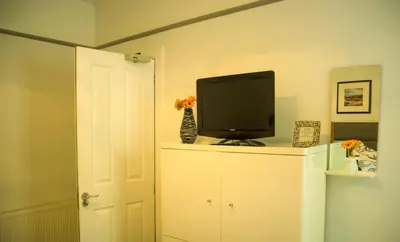a tv sitting on top of a white cabinet at Dana Villa Holiday Accommodation in Oban