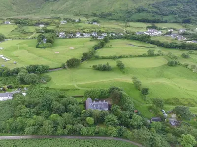an aerial view of a house in a green field at Butt Lodge in Lochranza