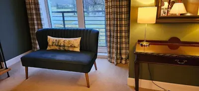 a chair and a desk in a room with a window at Butt Lodge in Lochranza