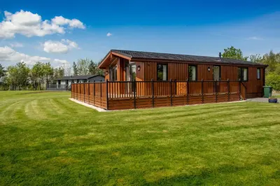 a house with a large yard in front of it at Linwater Caravan Park - Luxury Lodges and Static Caravans near Edinburgh in Newbridge